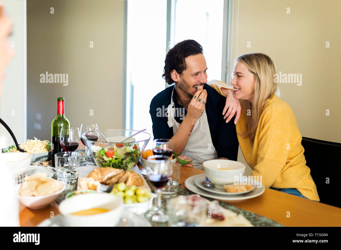 Amici divertendosi, mangiare il pranzo insieme, giovane flirtare al tavolo Foto Stock