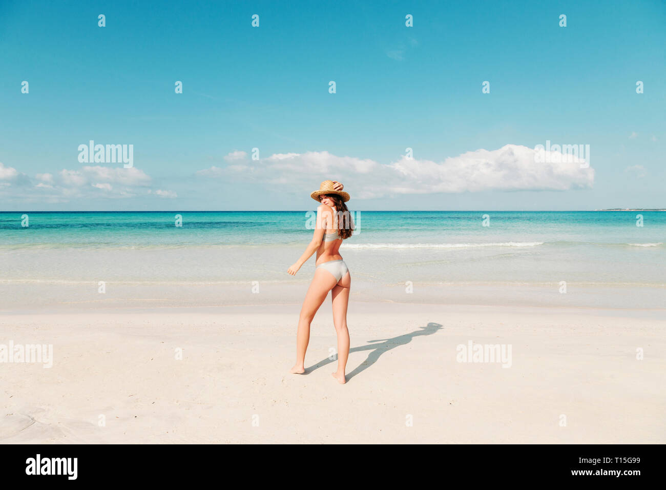 Spagna, Mallorca, vista posteriore di una giovane donna su vacanze a piedi sulla spiaggia Foto Stock