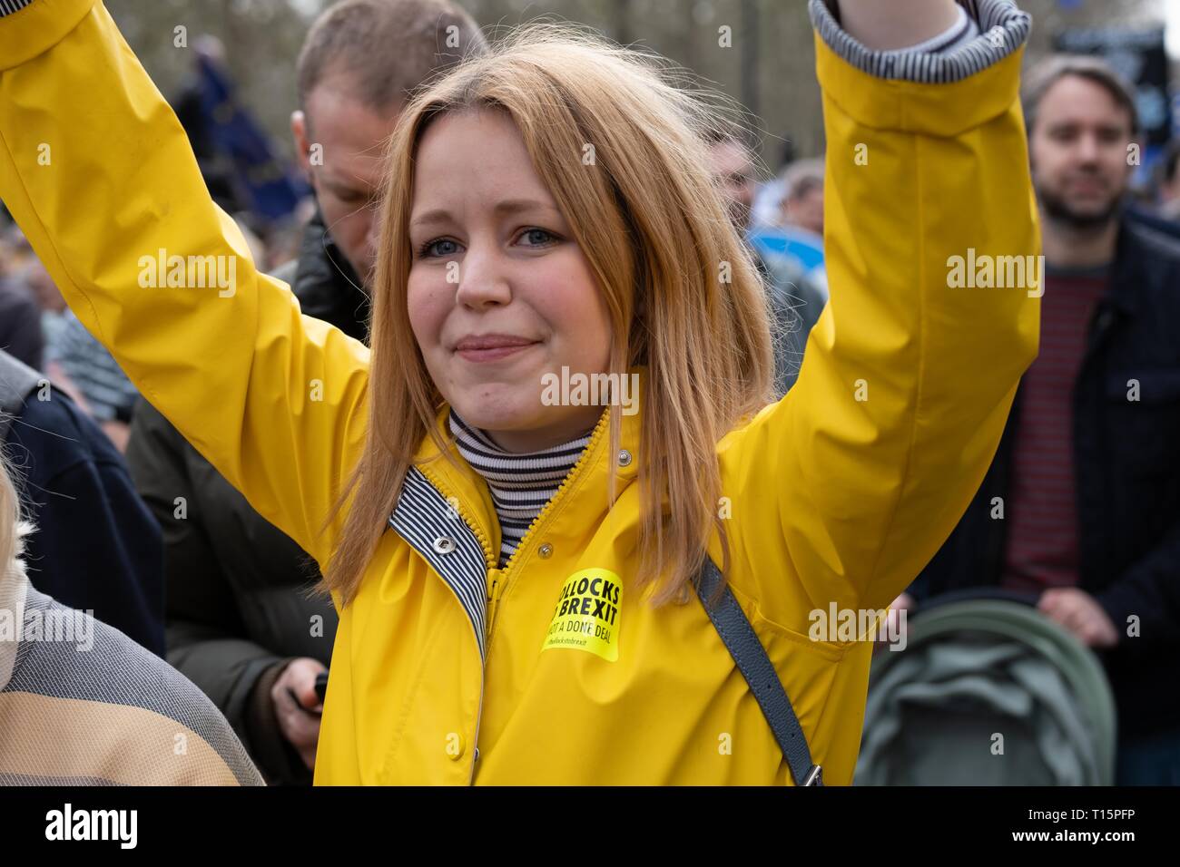 Londra, Regno Unito. 23 Mar, 2019. Donna in cappotto giallo tenendo premuto fino segno a popoli votazione marzo. Londra 23 marzo 2019 Credit: Chris Moos/Alamy Live News Foto Stock