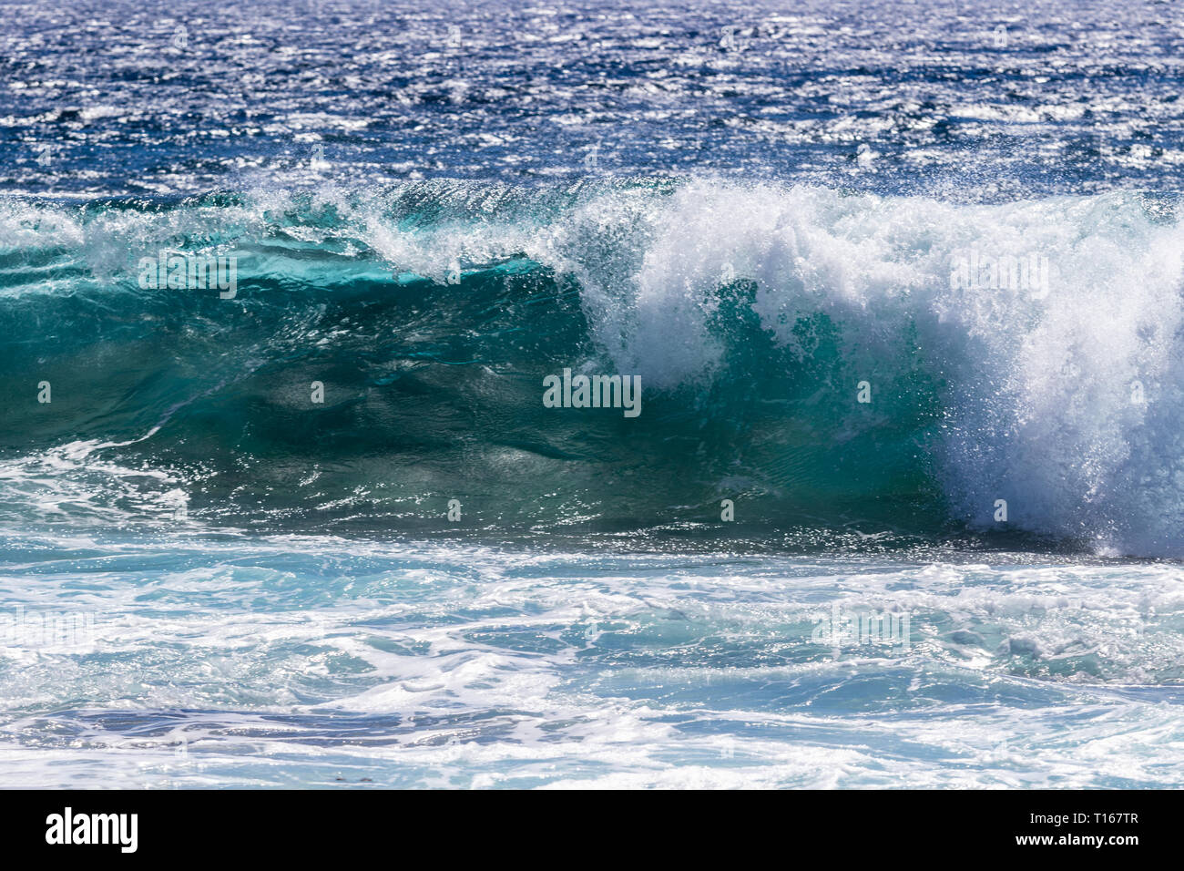 Rottura d'onda vicino a South Point, la Big Island delle Hawaii. Blu oceano pacifico in background. Foto Stock