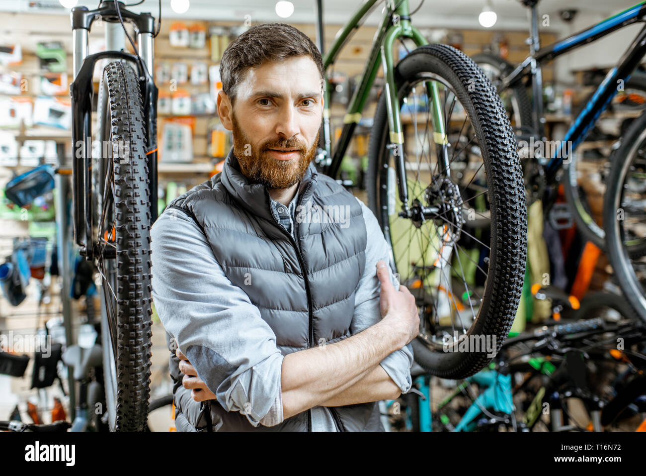 Ritratto di un uomo bello come un compratore o un venditore presso il negozio di biciclette Foto Stock