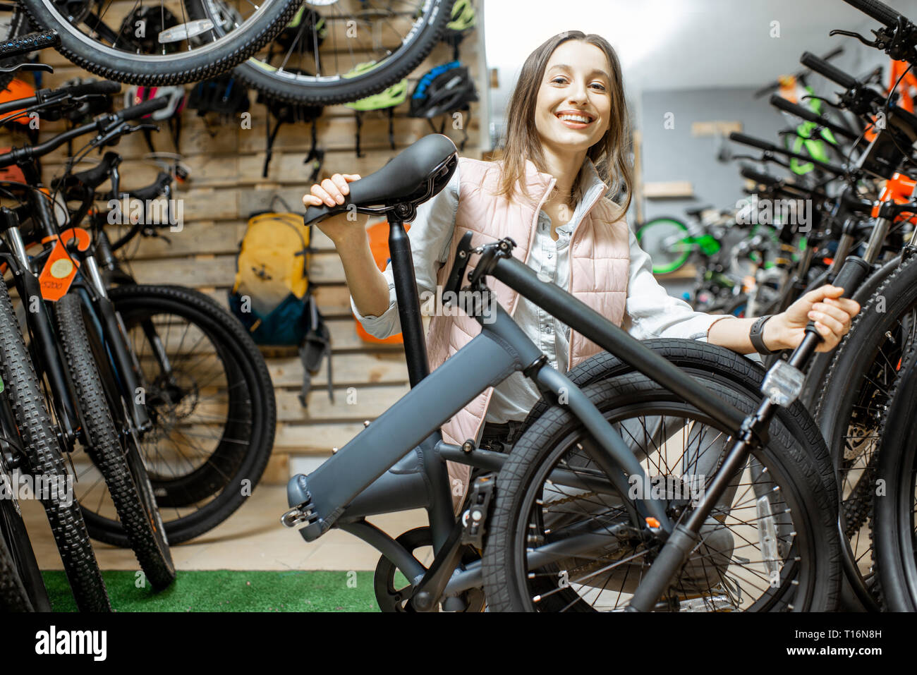 Ritratto di una donna elegante con bicicletta pieghevole al negozio di biciclette Foto Stock