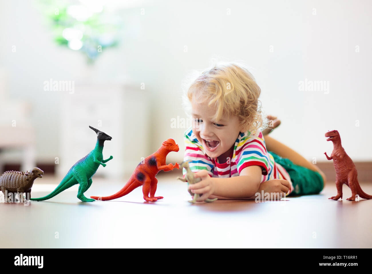 Bambini che giocano con variopinti dinosauri giocattolo. Giocattoli educativi per i bambini. Little Boy learning fossili e rettili. I bambini giocano con i giocattoli di dinosauri. Evol Foto Stock