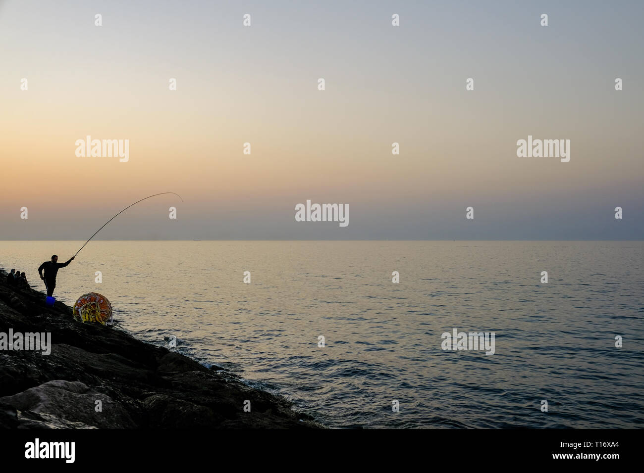 Dicembre 29, 2018 - Abu Dhabi, Emirati arabi uniti: Silhouette di un ​man pesca con una canna da pesca a sera Foto Stock