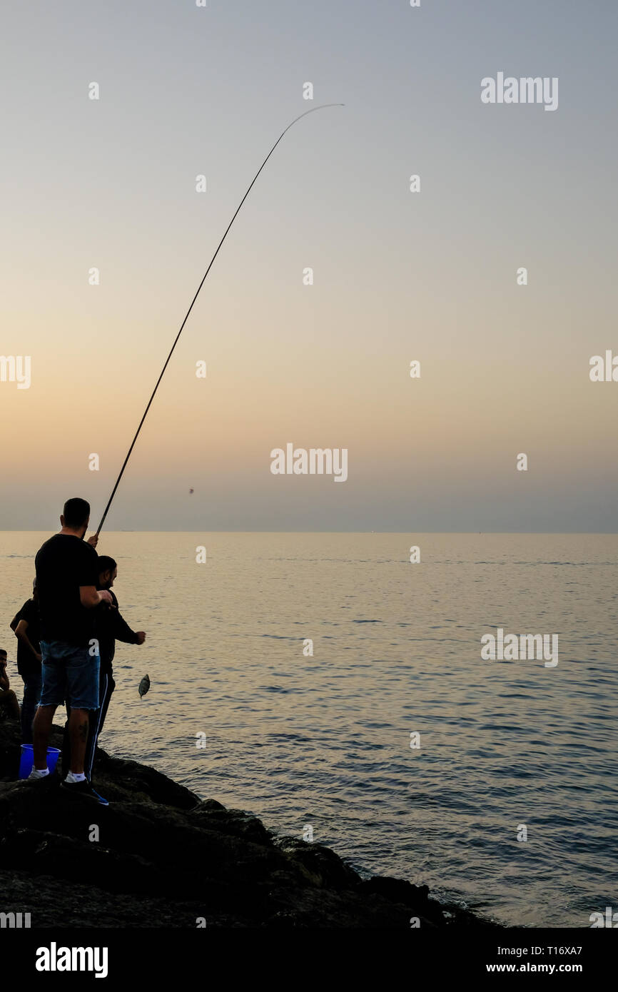 Dicembre 29, 2018 - Abu Dhabi, Emirati arabi uniti: Silhouette di un ​man pesca con una canna da pesca a sera Foto Stock