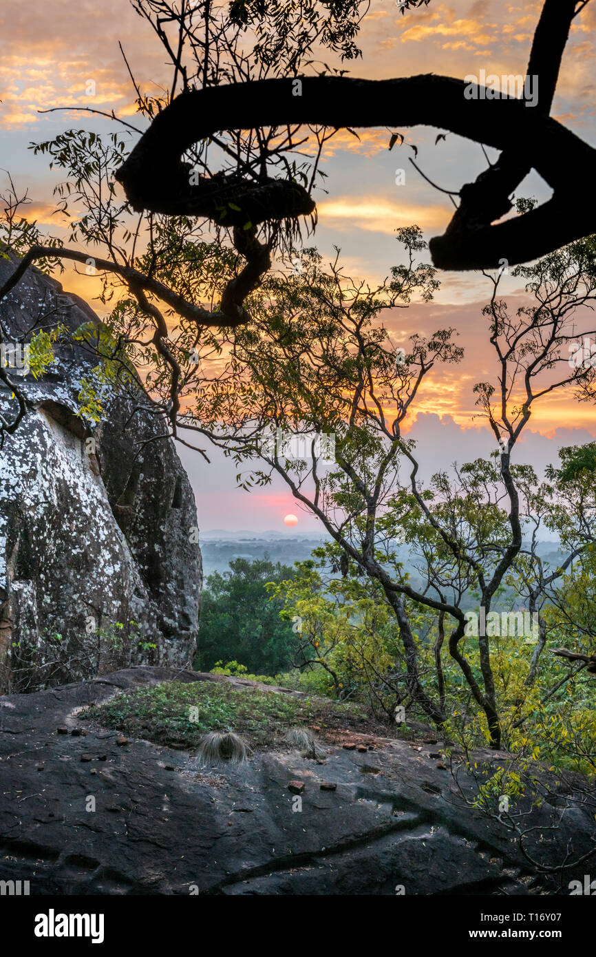 Il sole tramonta oltre le antiche rovine della fortezza sulla sommità di Sigiriya nella provincia centrale dello Sri Lanka, costruito da Re Kassapa, chi ha ucciso la sua f Foto Stock