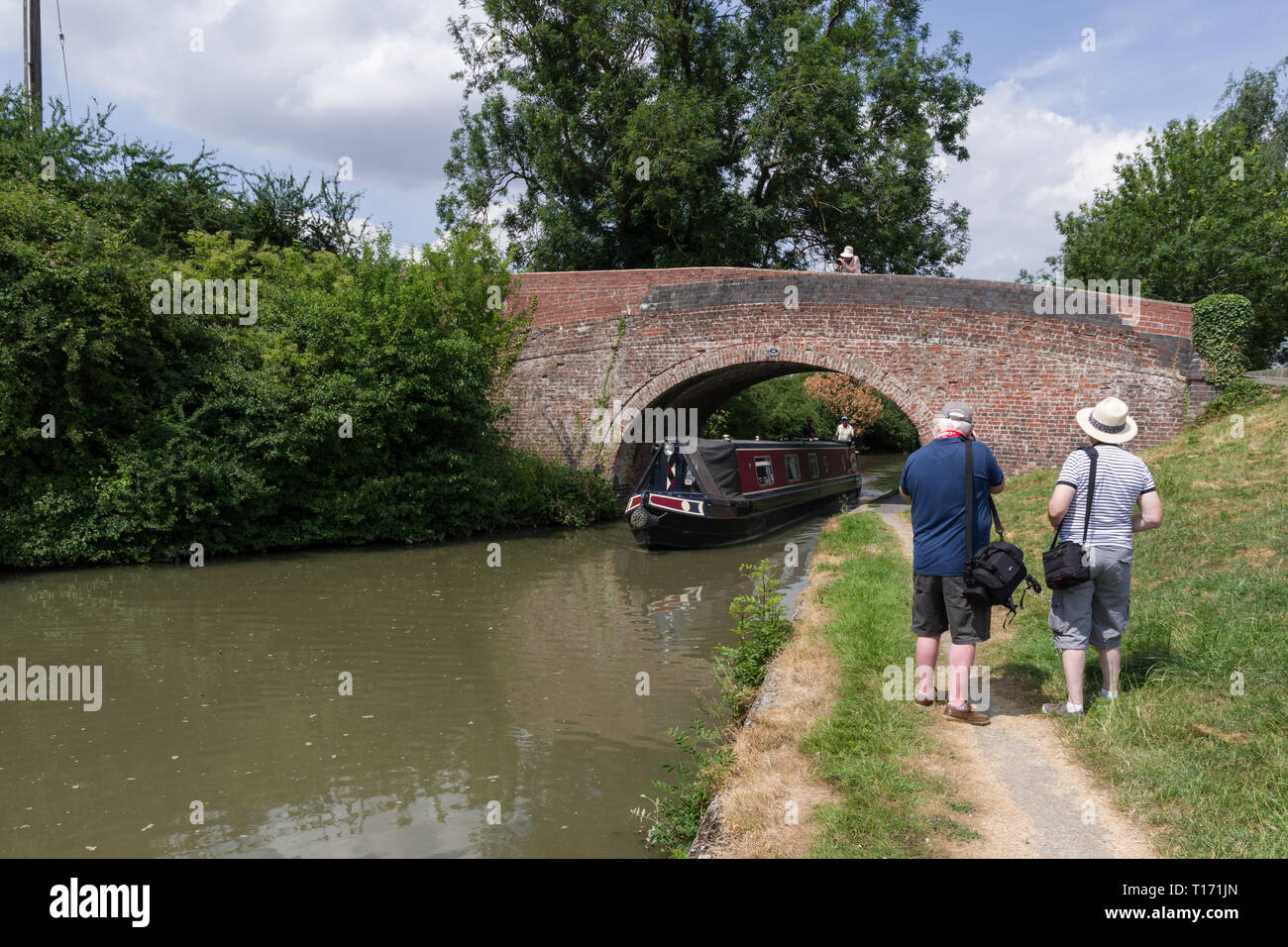 Tre anziani, membri di una U3un gruppo di fotografia, scattare foto di un narrowboat sul canal a Blisworth, Northamptonshire, Regno Unito Foto Stock