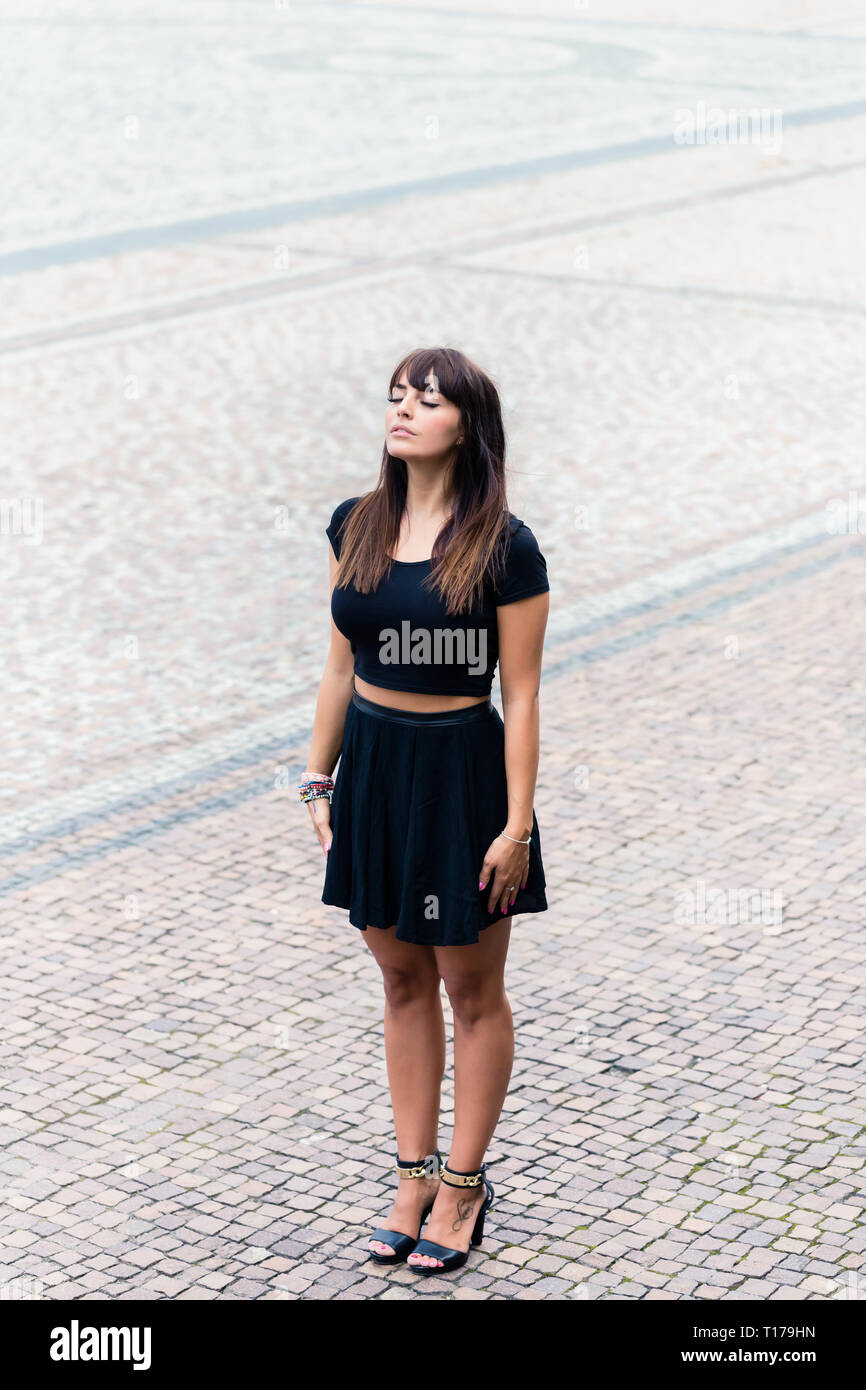 Elegante giovane donna in piedi su ciottolo Foto Stock