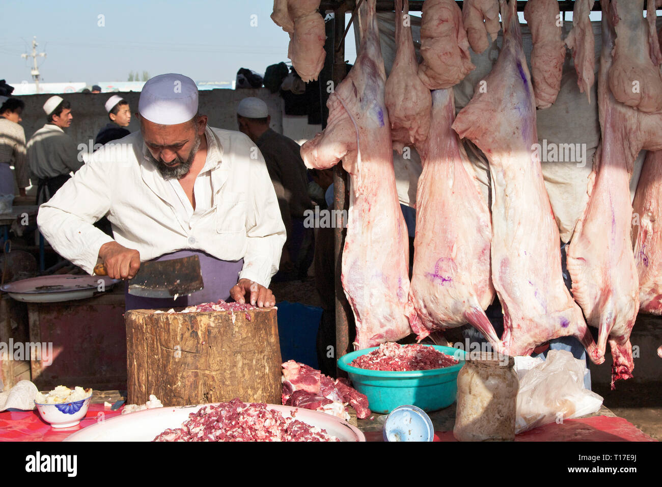 Un macellaio Uighur che lavora al mercato del bestiame della domenica appena fuori Kashgar, regione autonoma di Xinjiang, Cina. Foto Stock