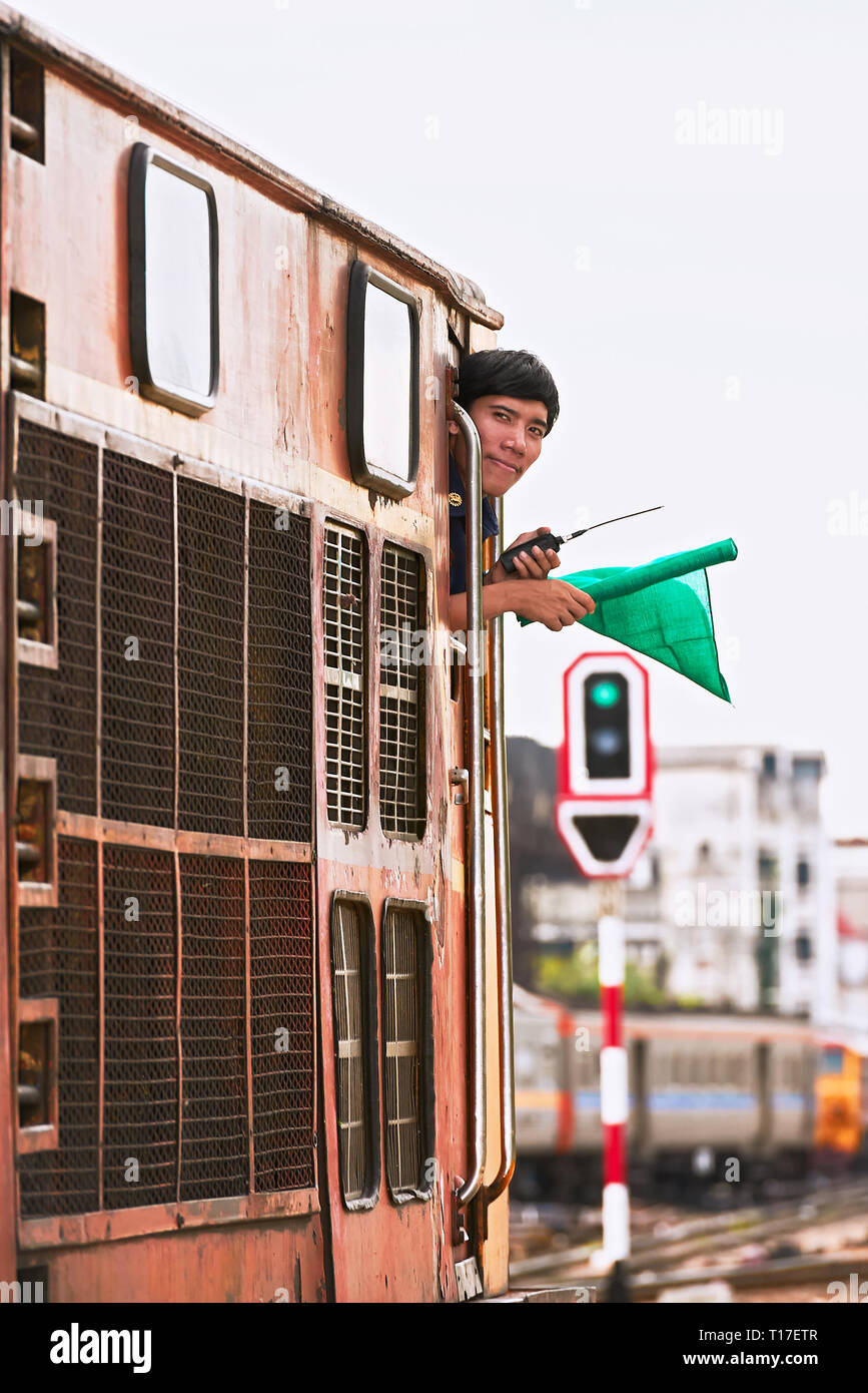 Hualamphong Stazione ferroviaria centrale di Bangkok, Tailandia - 14 Giugno 2011: il conducente di un treno diesel segnalazione con una bandierina verde prima di partire Foto Stock
