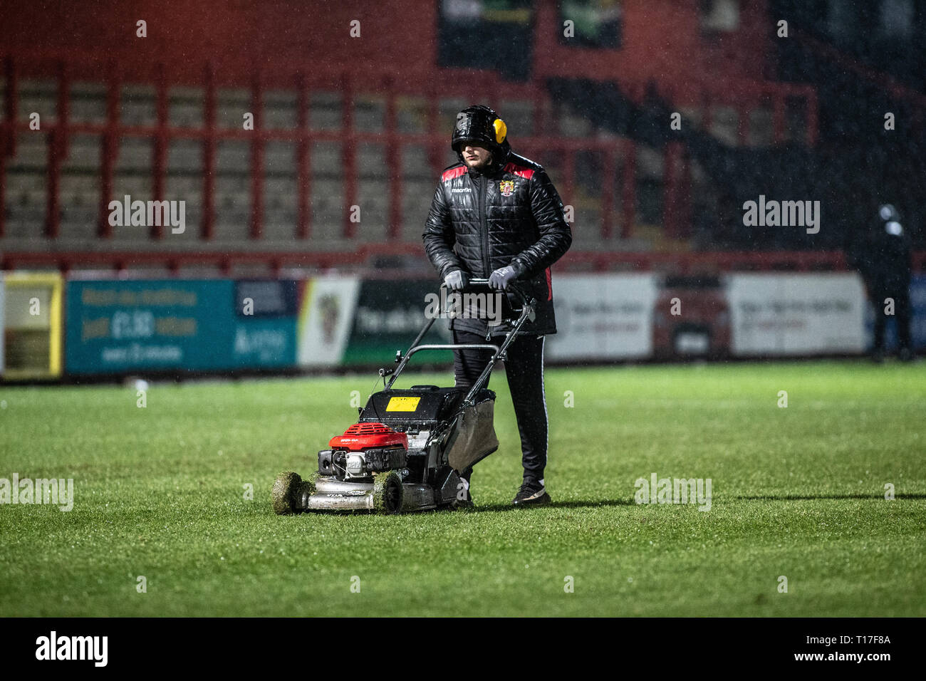 Groundsman mantenendo football pitch in Rain Foto Stock
