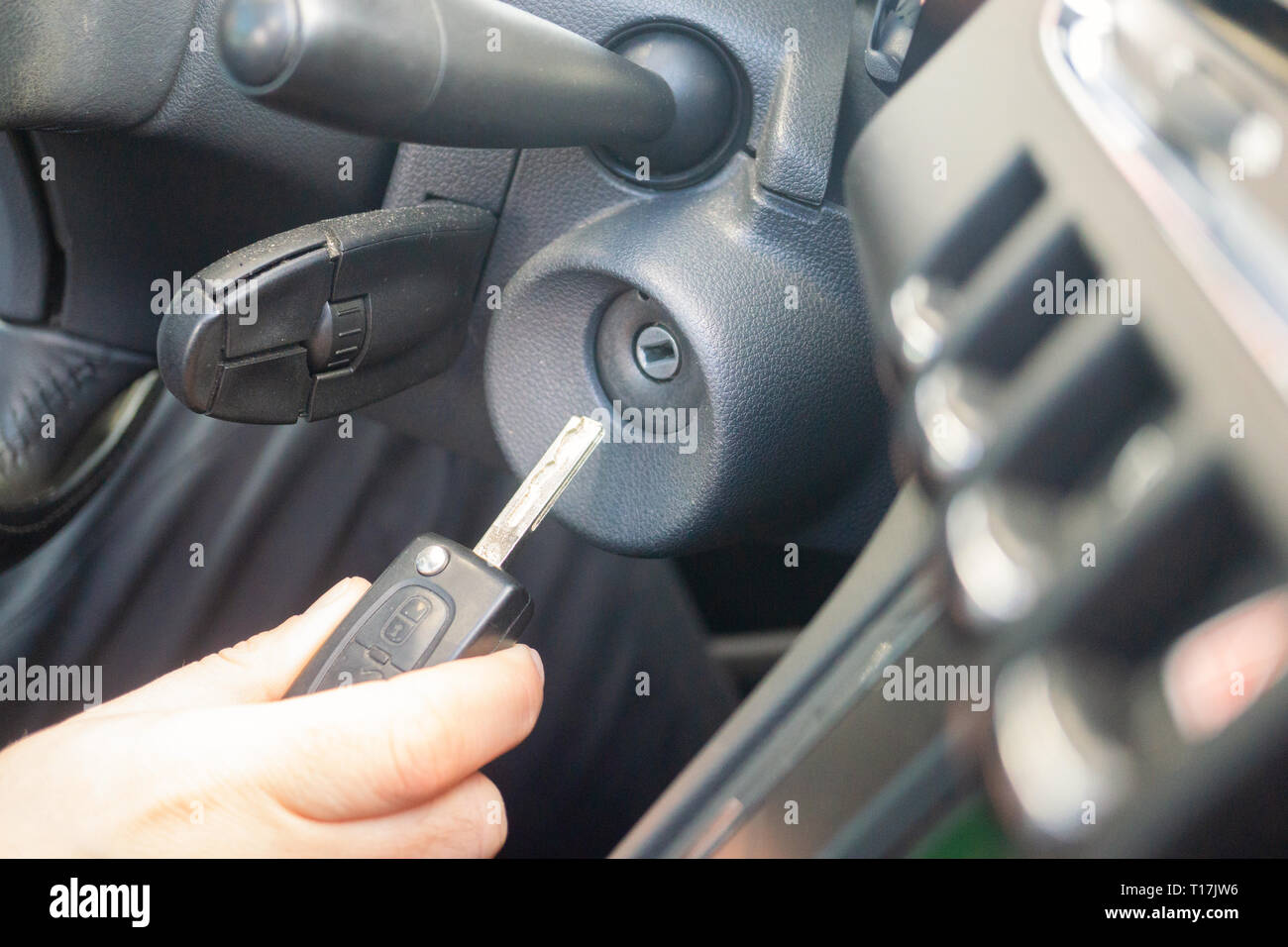 Primo piano interno veicolo della mano che tiene la chiave nel contatto, avviare il motore chiave. Foto Stock