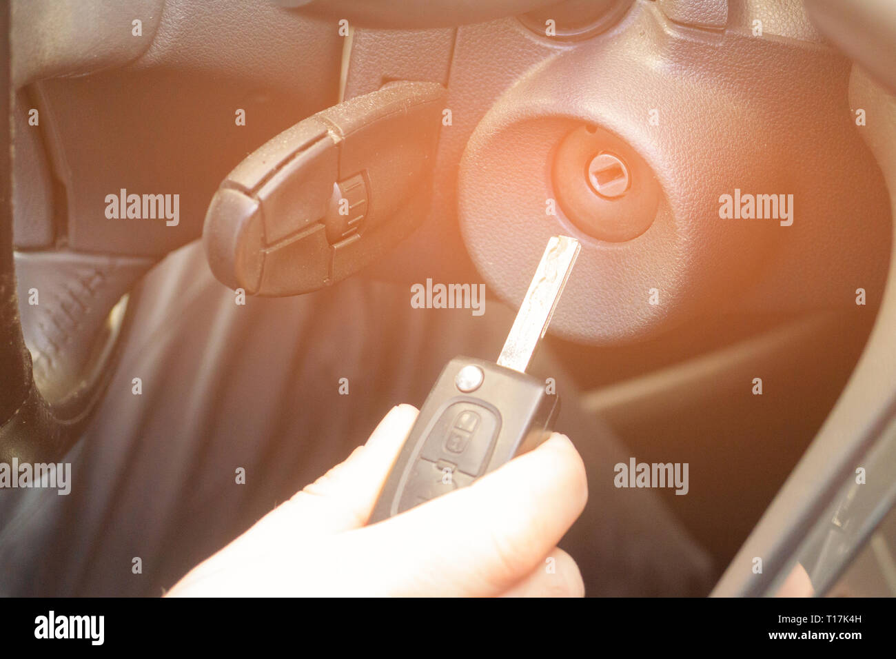 Primo piano interno veicolo della mano che tiene la chiave nel contatto, avviare il motore chiave. Foto Stock