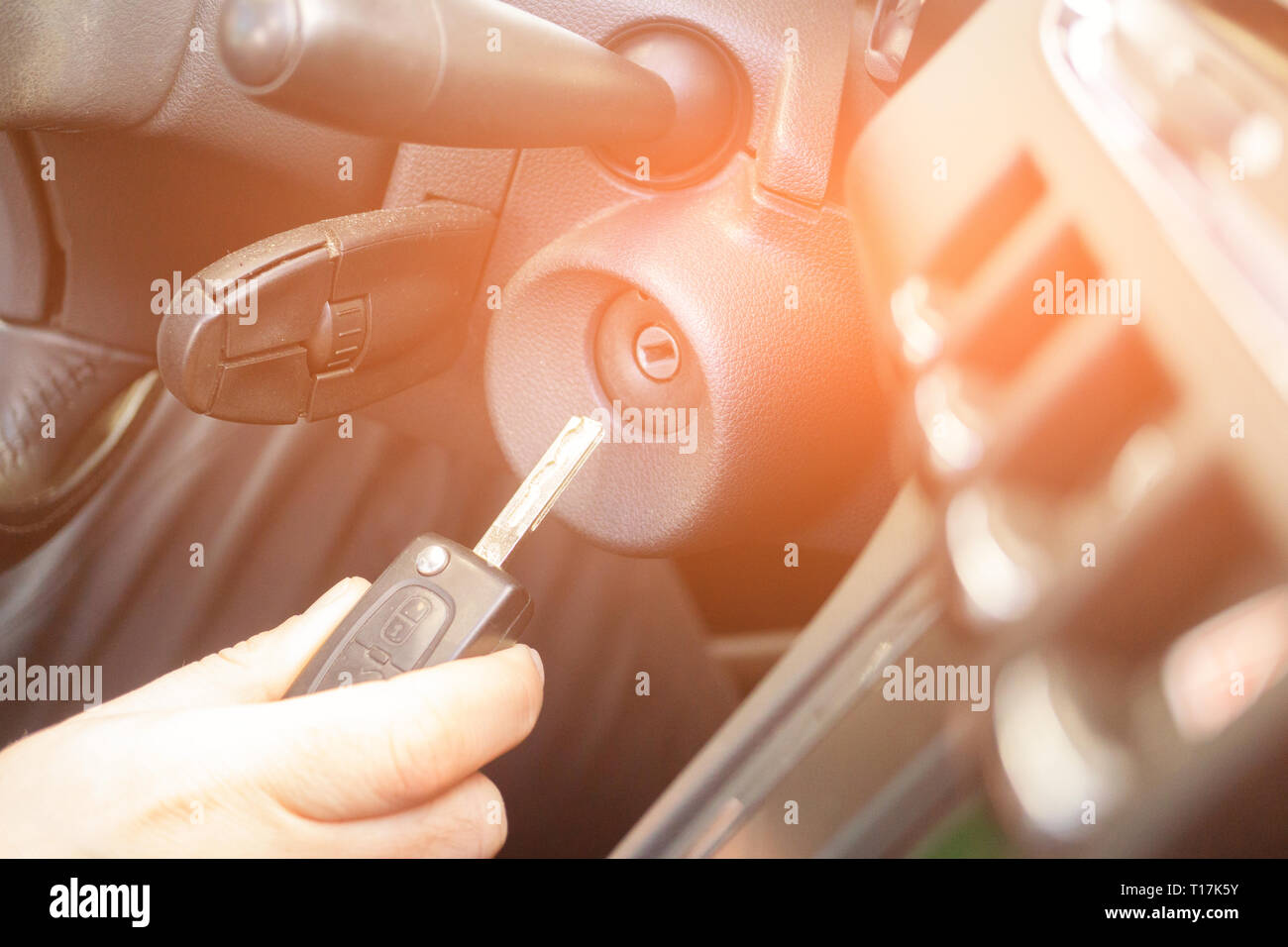 Primo piano interno veicolo della mano che tiene la chiave nel contatto, avviare il motore chiave. Foto Stock