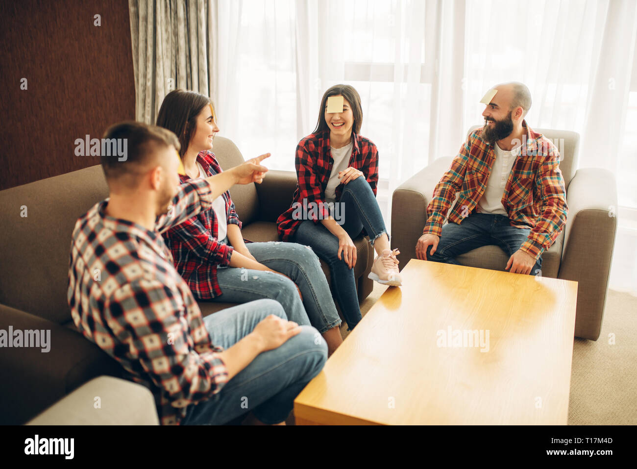 Amici giocando sticker note a fronte gioco Foto Stock