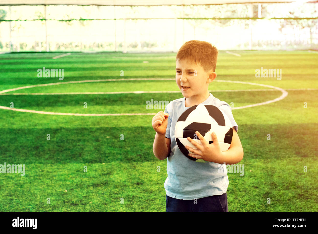 Ritratto di un giovane giocatore di calcio scuola kid al campo di calcio stesso motivante Foto Stock