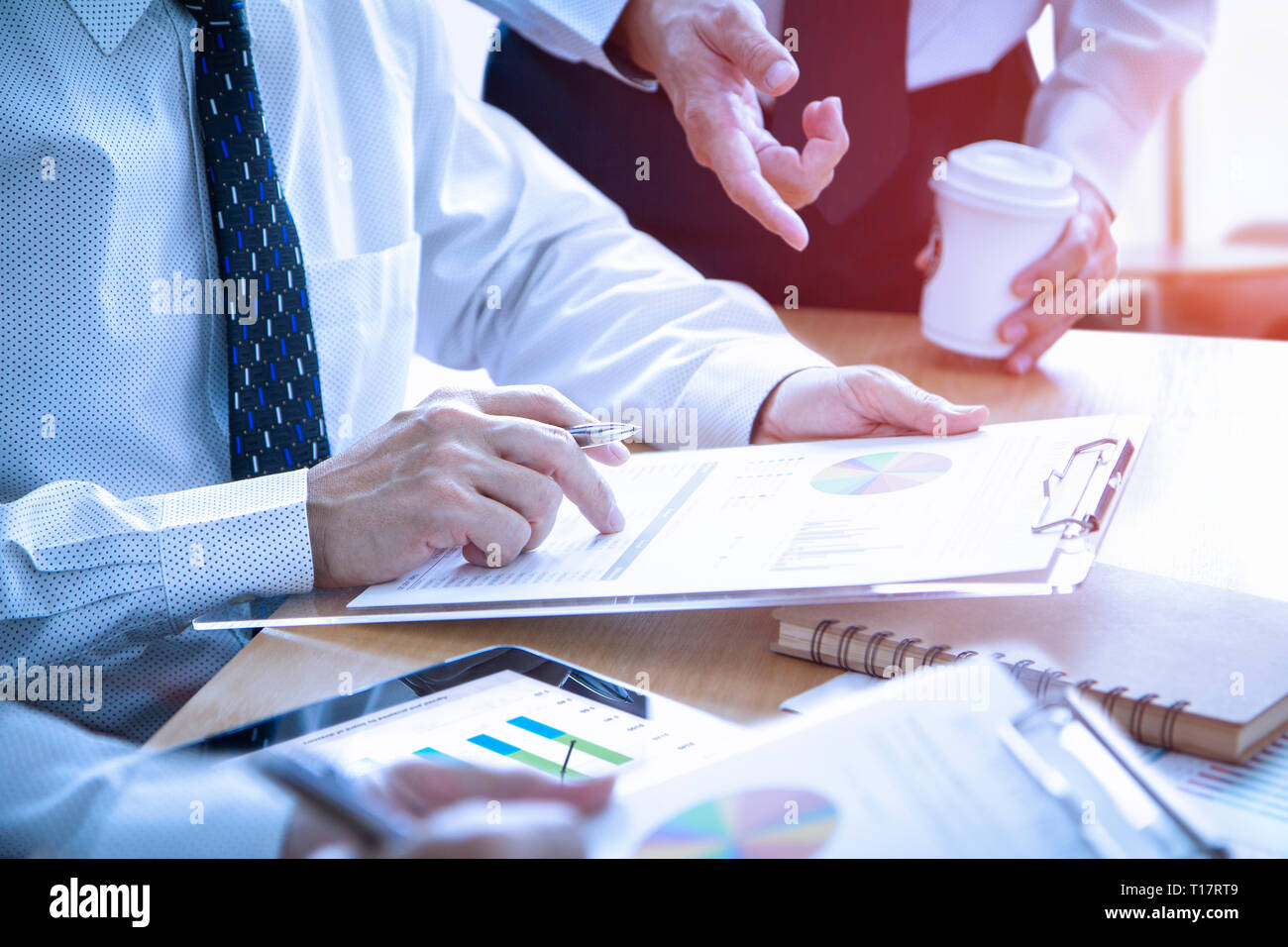 Imprenditori nel corso di una riunione sono profondamente rivedendo un report finanziari per un ritorno sugli investimenti o di investimento analisi di rischio. Foto Stock