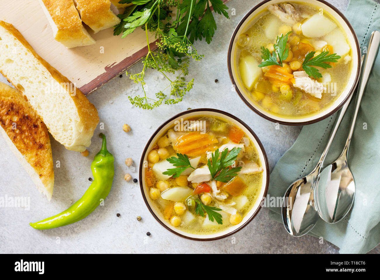 In casa la zuppa calda con verdure, pollo e Piselli Ceci. Cucina orientale. Il concetto di mangiare sano. Vista superiore piatta sullo sfondo dei laici. Foto Stock