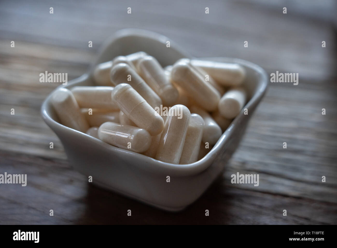 Vitimin pillole ammucchiati in una piccola ciotola di porcellana Foto Stock