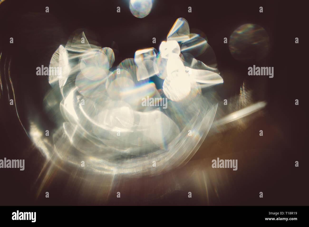 Real lens flare effetto di luce su uno sfondo scuro. La luce solare rifratta in vetro. Può essere utilizzato nelle tue immagini per creare vari effetti Foto Stock