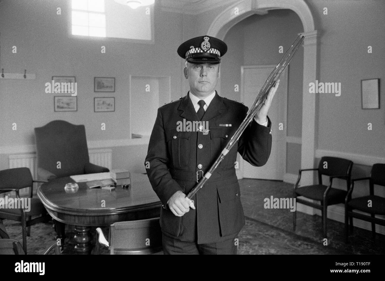 Legge e ordine delle punizioni corporali sull'Isola di Man 1970s . Il sovrintendente Alan Killip, l'ufficiale di polizia di grado più alto dell'Isola di Man, con una verga di betulla a Castle Rushen, Castletown. La verga di betulla di Manx era ancora usata per punizioni corporali sull'Isola di Man durante gli anni '1970 Amministrato dalla polizia a piccoli trasgressori. 1978 HOMER SYKES Foto Stock