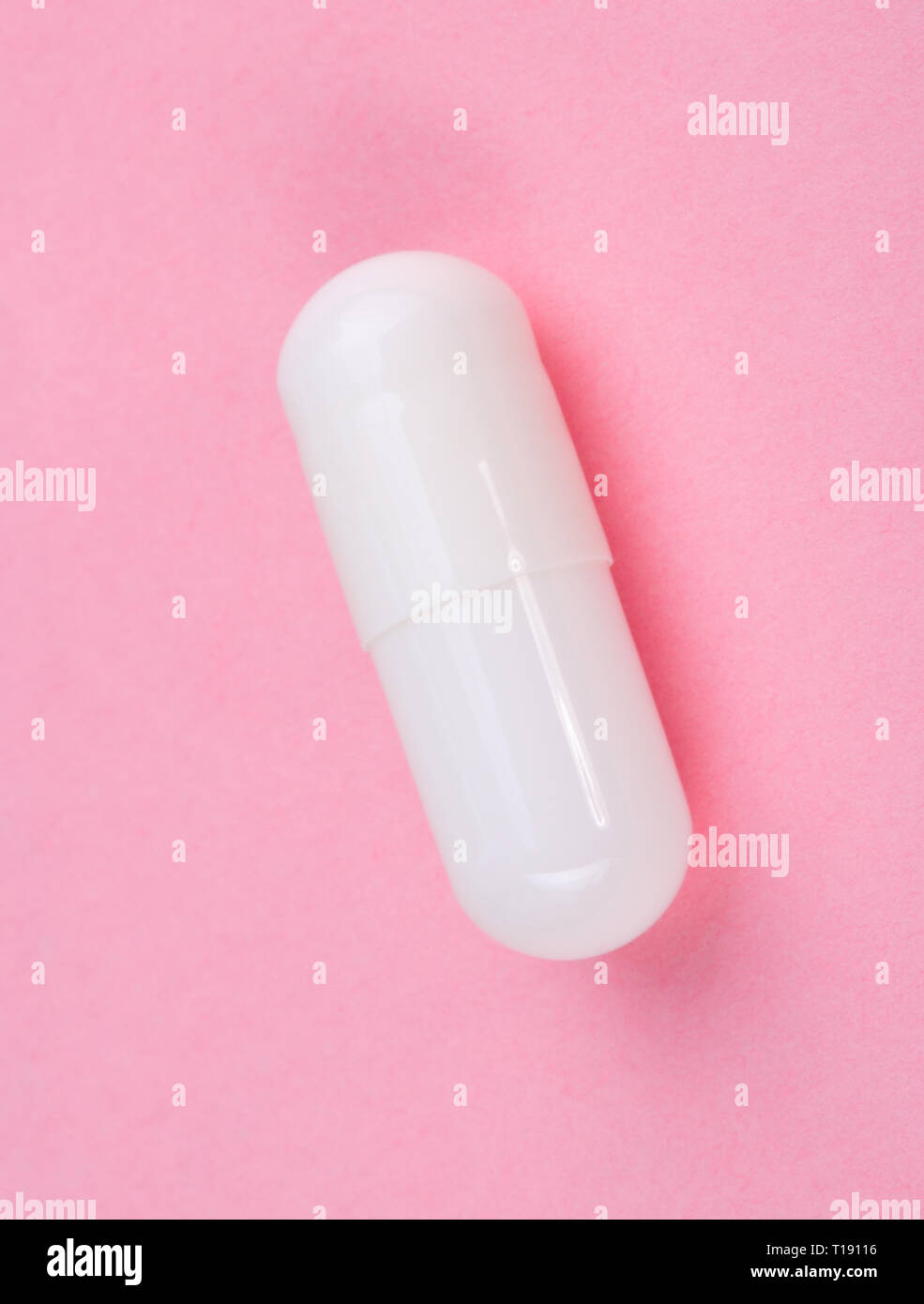 Pillola bianco su sfondo rosa Foto Stock