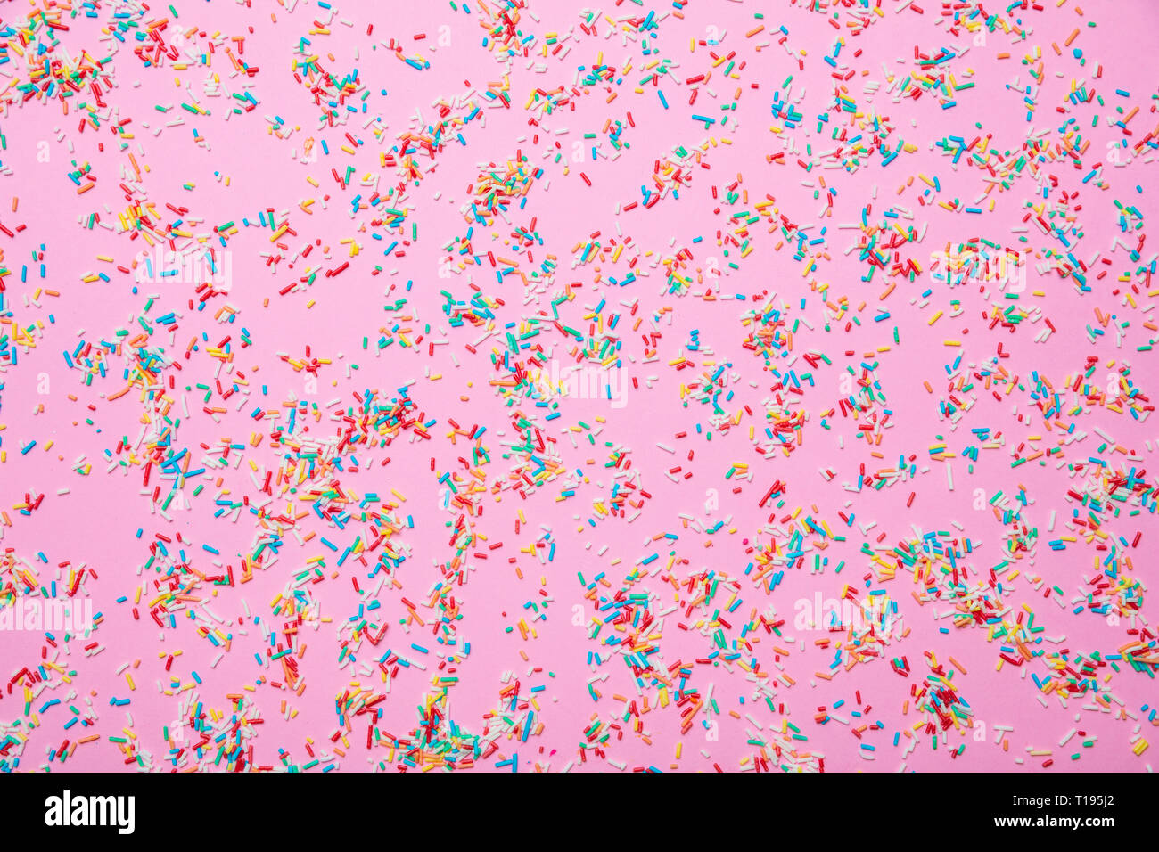 Concetto di compleanno. Negli zuccherini colorati in rosa pastello sfondo, vista dall'alto Foto Stock