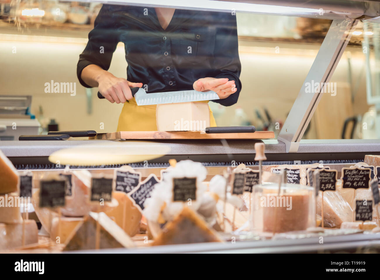 Commessa donna formaggio di smistamento nel supermercato display Foto Stock