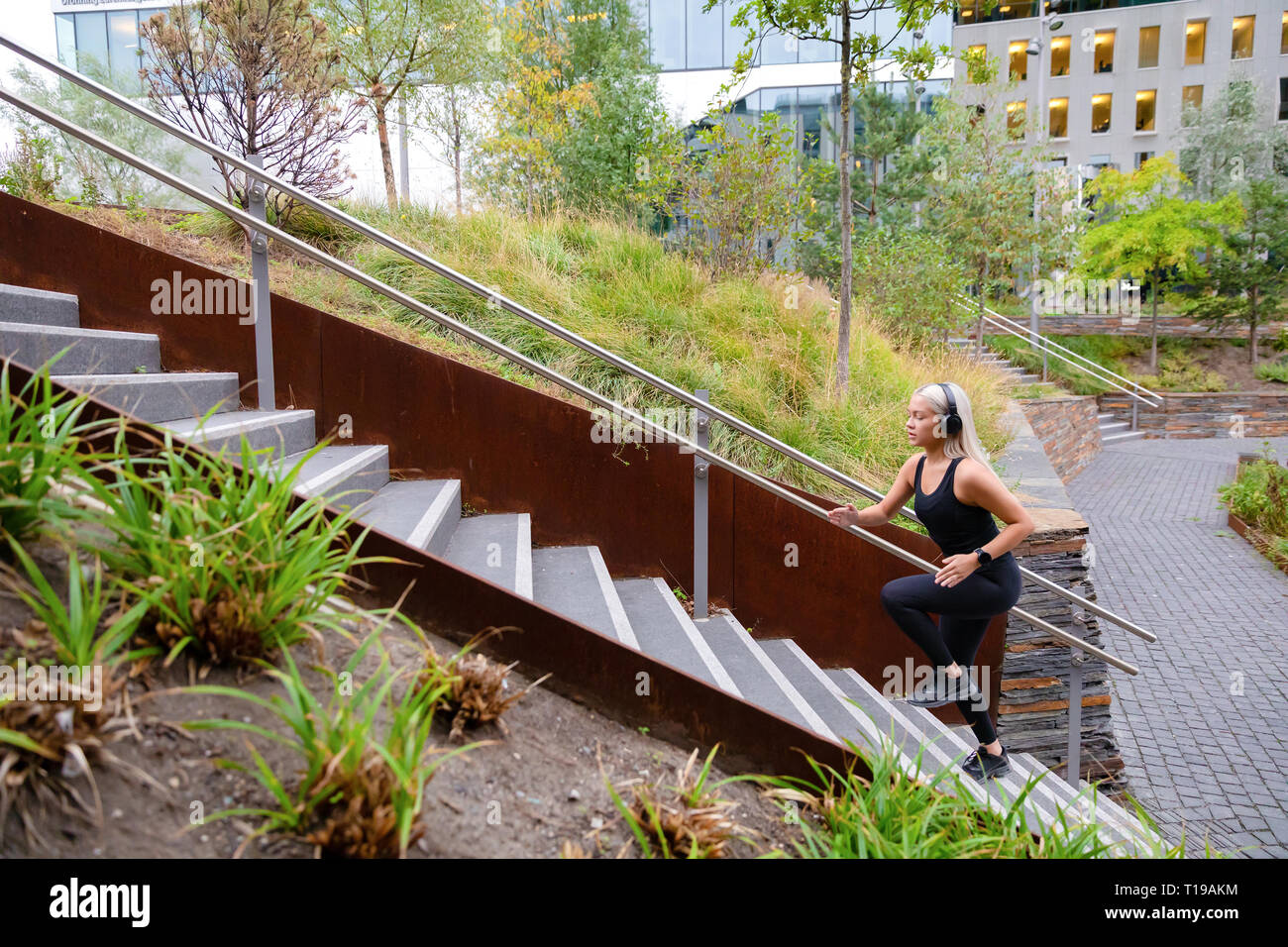 Montare le donne sportive esecuzione di allenamento a intervalli in scale nel parco della città Foto Stock