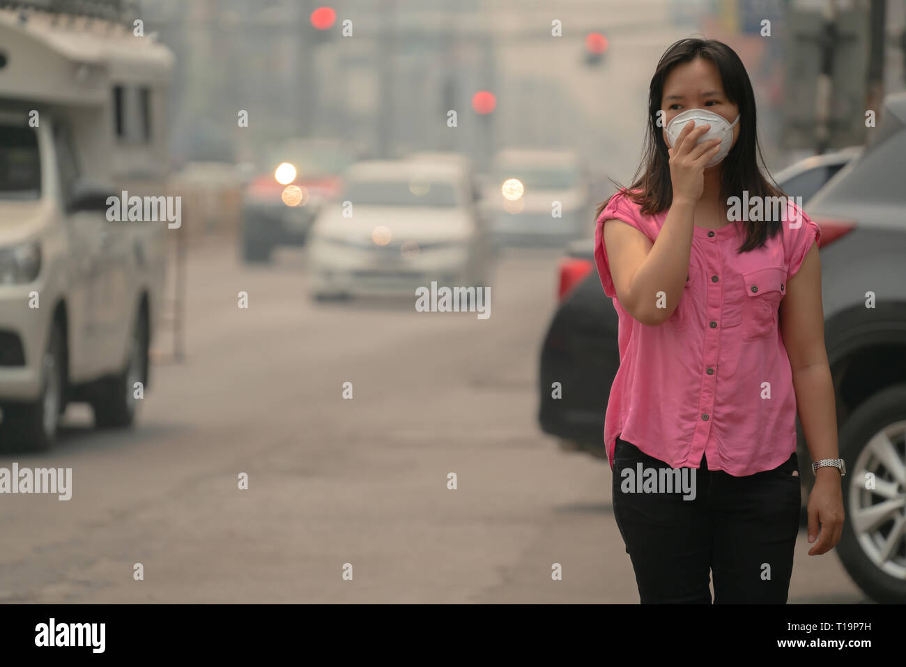 Giovane donna che indossa la maschera protettiva nella città street, Chiang Mai Thailandia Foto Stock