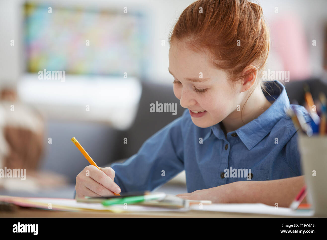 Dai Capelli rossi ragazza facendo i compiti di scuola Foto Stock