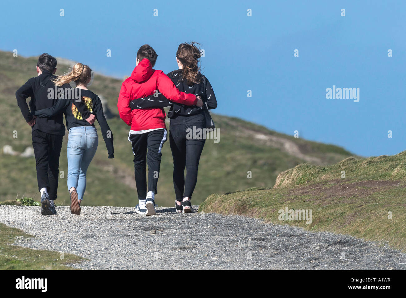 Giovani adolescenti con le loro braccia intorno a ogni altro a piedi lungo un sentiero. Foto Stock