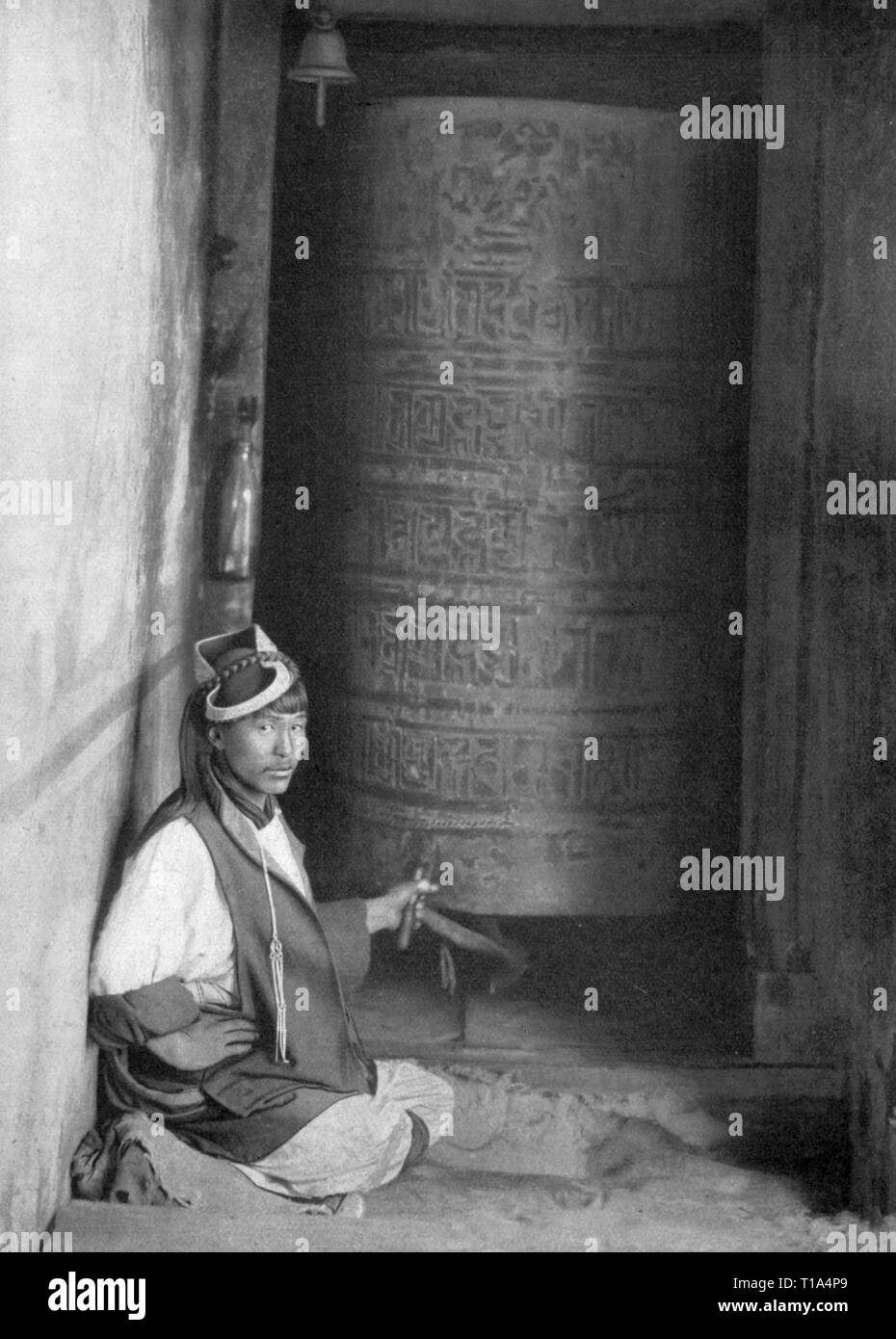 La religione, Buddismo, uomo con ruota di preghiera, Tibet, da: Georg Buschan, 'Die Sitten der Voelker', Stuttgart, 1914 - 1922, Additional-Rights-Clearance-Info-Not-Available Foto Stock