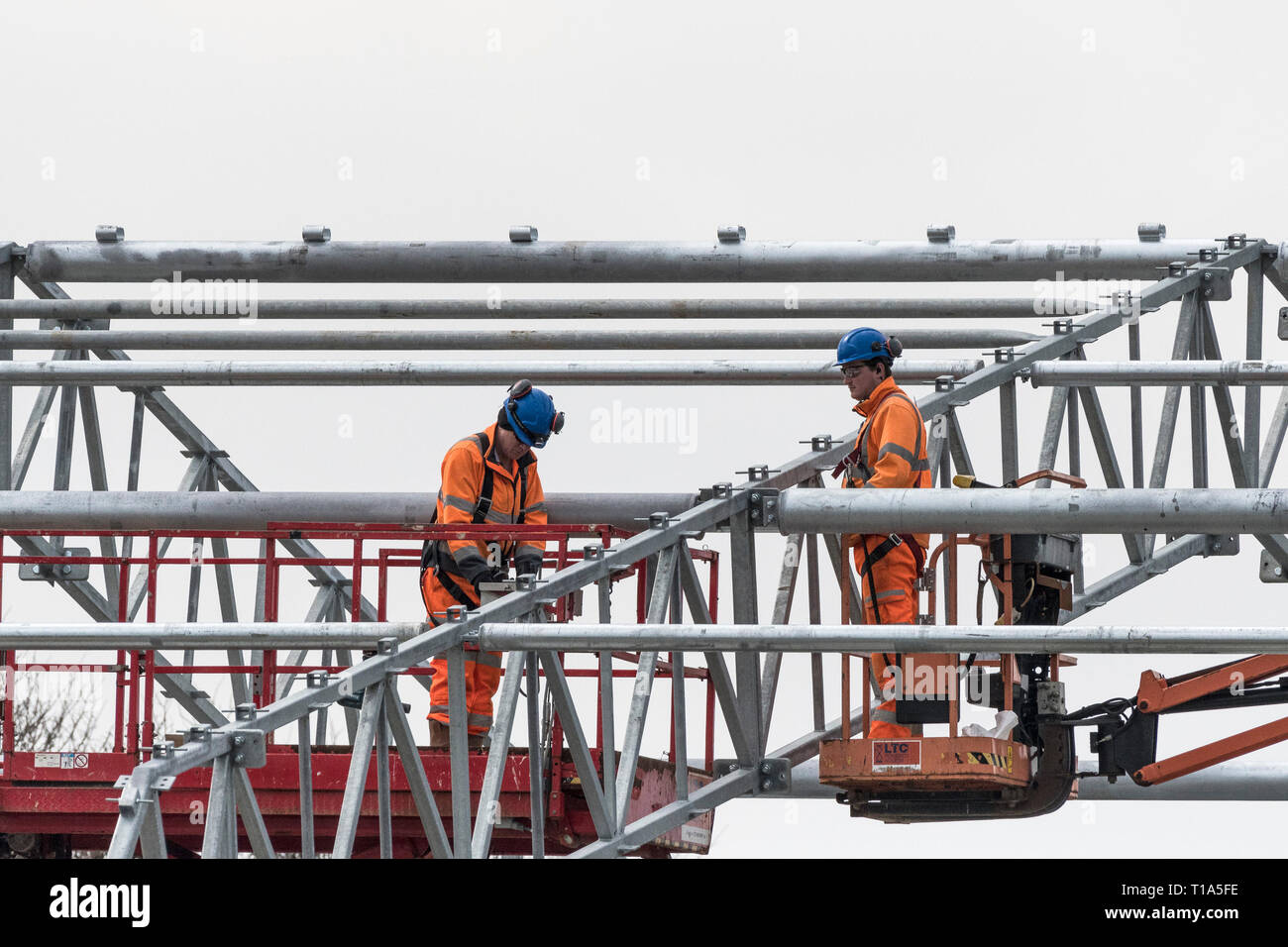 Erettori di acciaio lavorando sul quadro di un nuovo edificio. Foto Stock