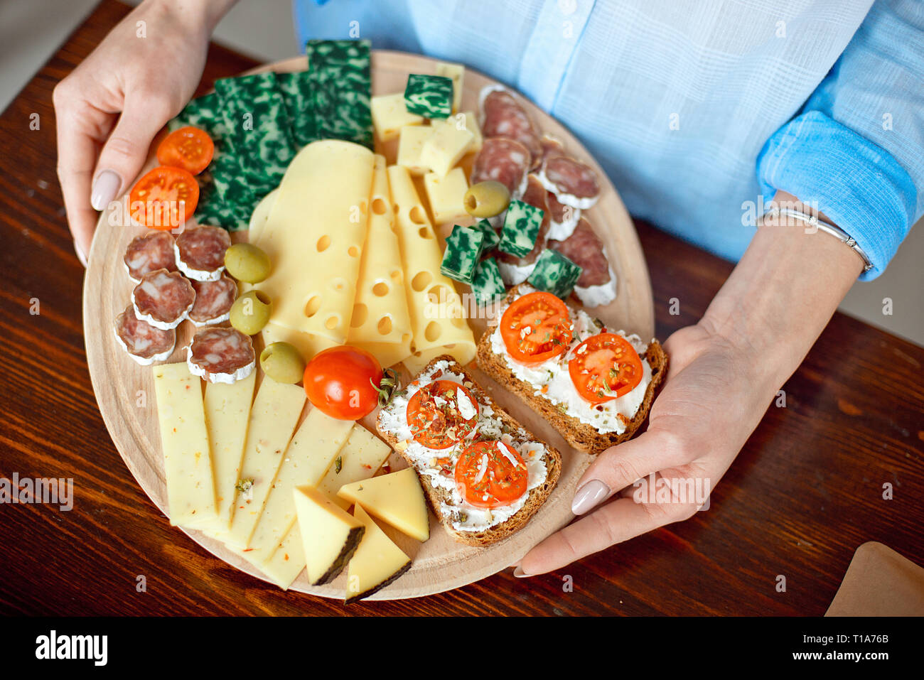Close-up donna detiene un piatto di formaggio nelle sue mani. Foto Stock