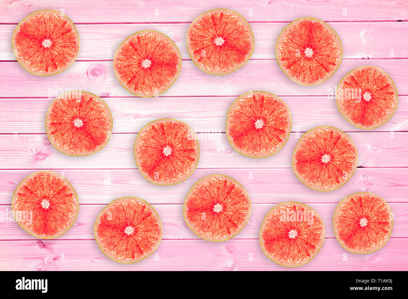 Molti freschi fette di pompelmo rosa su tavole di legno, estate concetto di sfondo Foto Stock