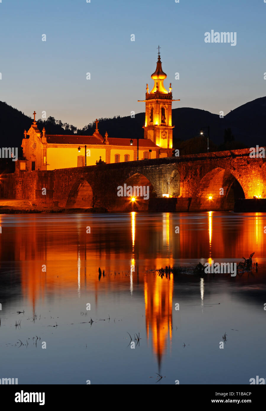 Il vecchio ponte romanico e la chiesa di Ponte de Lima di notte Foto Stock