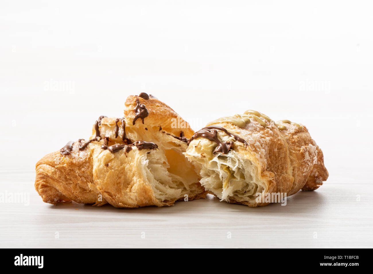 Avidi tortine farcite con cioccolato e pistacchio su un tavolo di legno Foto Stock