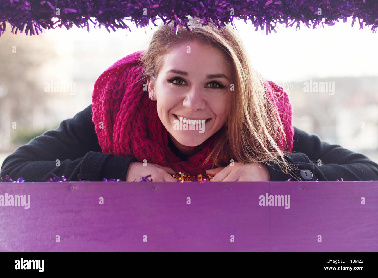 Ritratto di donna sorridente in inverno indietro cappotto e sciarpa rosa. Foto Stock