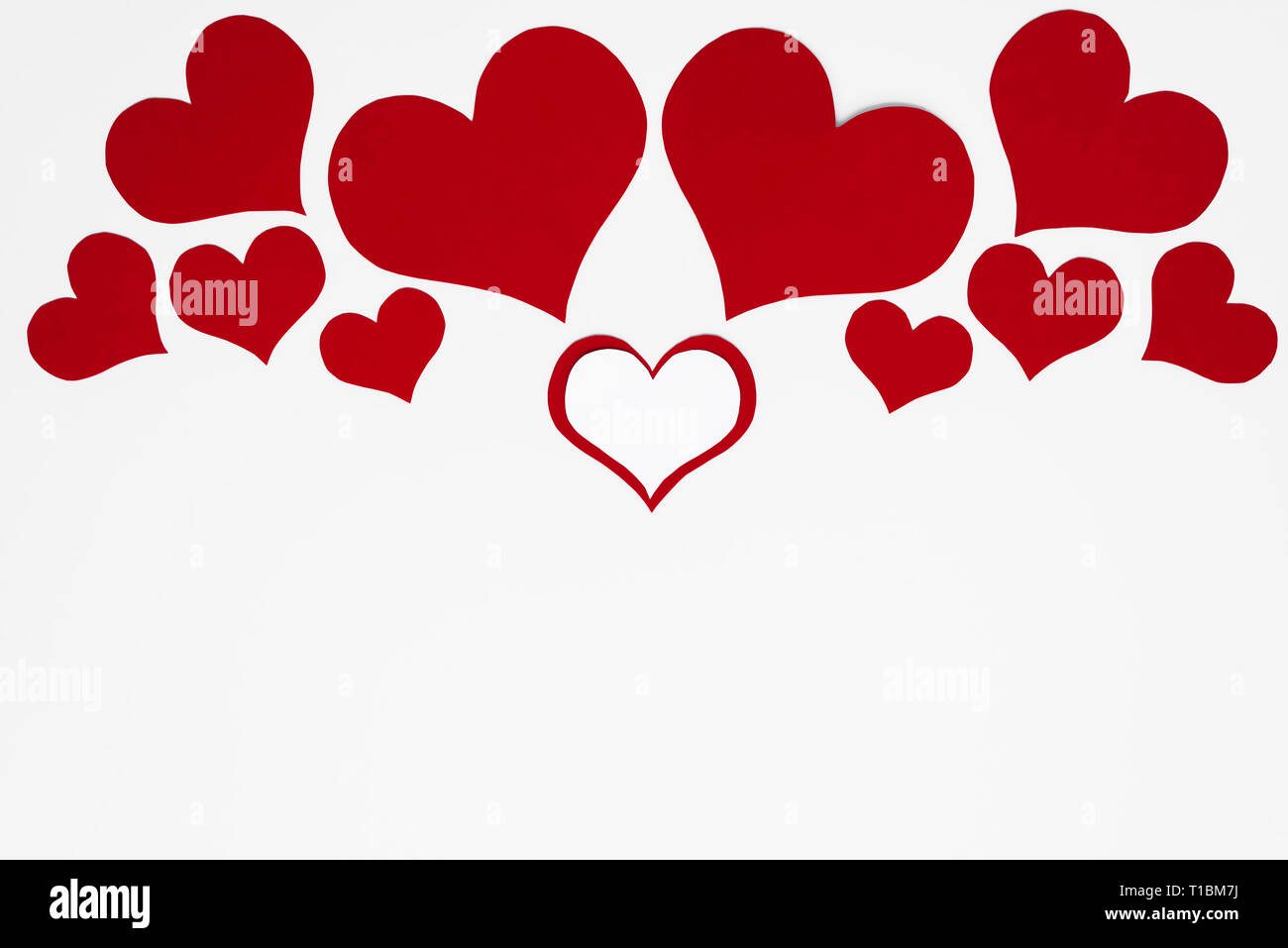 Un romantico rosso e bianco cuori su uno sfondo bianco come un simmetrico telaio superiore per una copia dello spazio per Happy Valentines il testo. Concetto per le madri o Womens giorno Foto Stock