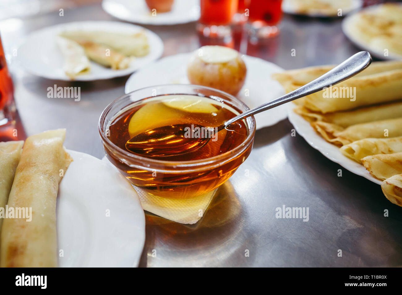 Frittelle di formaggio sono serviti con miele su una piastra bianca Foto Stock