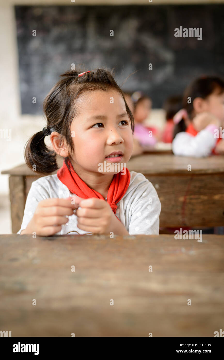 Elementare scuola di età i bambini che frequentano la classe in una classe rurale nella regione di Guangxi del centro sud della Cina. Foto Stock