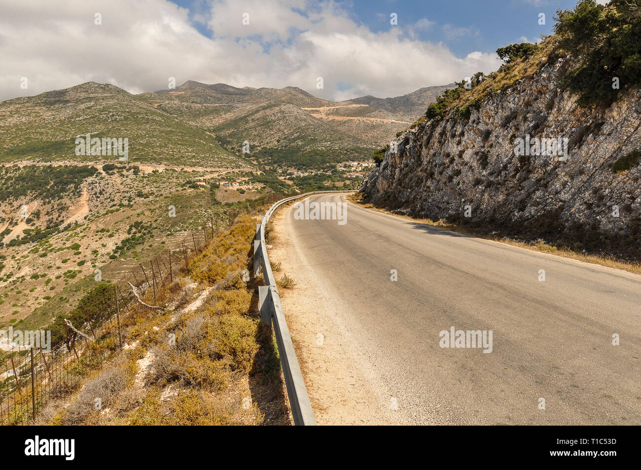 Paesaggio in prospettiva della strada di montagna durante la giornata di sole per le vacanze. Roadtrip attraverso la valle fino alla collina. Foto Stock