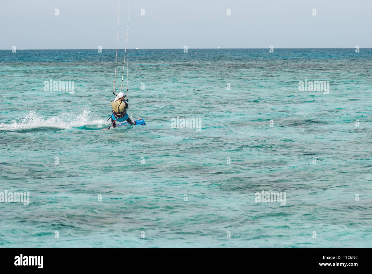 Professional kiter glide la superficie dell'acqua dell'oceano a grande velocità. Vista posteriore dietro ampia shot Foto Stock