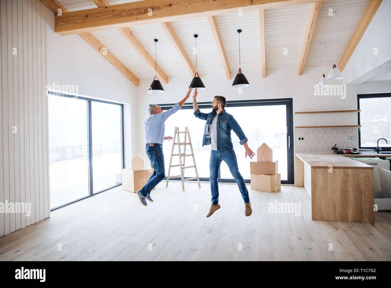 Un uomo maturo salta con il suo anziano padre nella nuova casa, un nuovo concetto di casa. Foto Stock