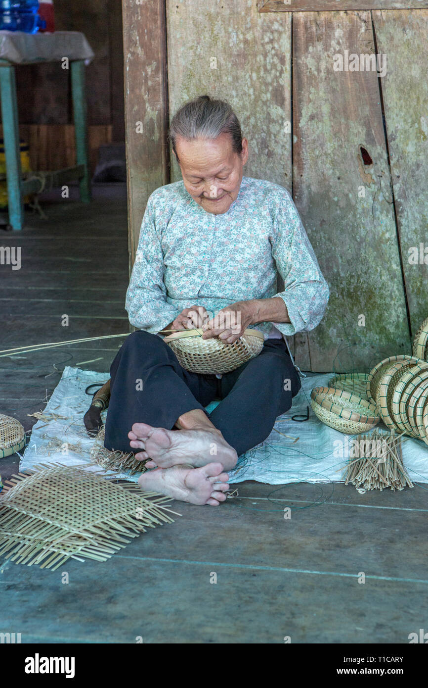 Una vecchia signora rendendo ceste in Vietnam Foto Stock