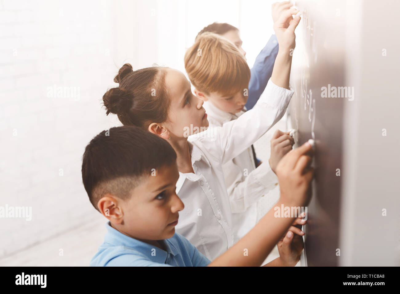 I bambini la scrittura di equazioni matematiche sulla scheda Foto Stock
