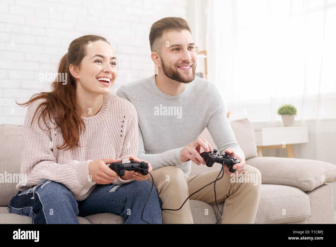 Coppia felice di giocare con i videogiochi e divertirsi insieme Foto Stock