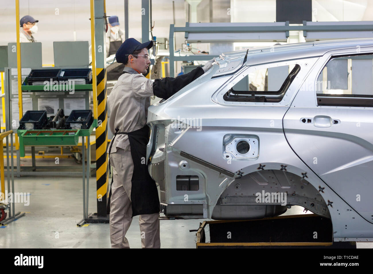 Russia, Izhevsk - Dicembre 15, 2018: Lada Automobile impianto Izhevsk, parte del gruppo AVTOVAZ. Il lavoratore è mettere la porta del bagagliaio per una nuova vettura. Foto Stock