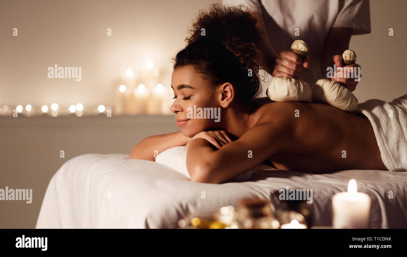 Donna godendo di erbe massaggio alla schiena in beauty spa Foto Stock